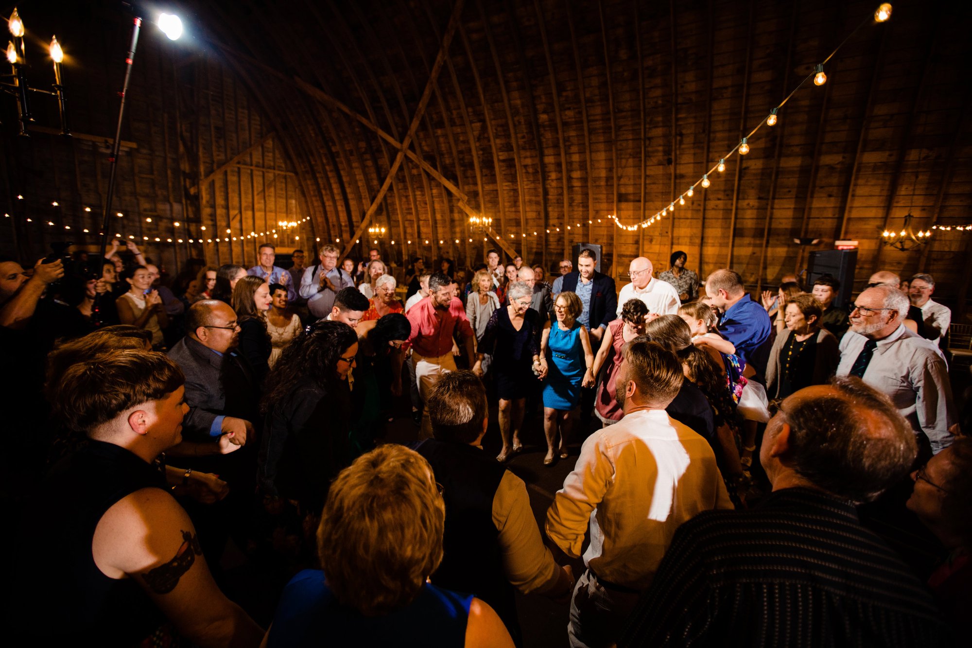 A packed dance floor under the barn's string lights late in the night.