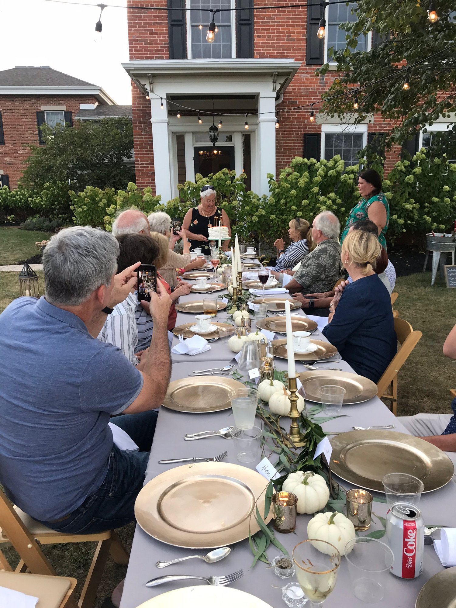 A farm dinner laid out in front of the farmhouse.